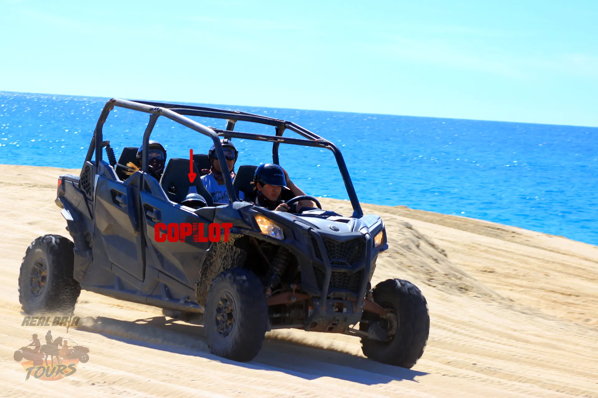 Blue QUAD UTV buggy with tourists manejando on playa de arena with turquoise ocean water in Baja California Sur