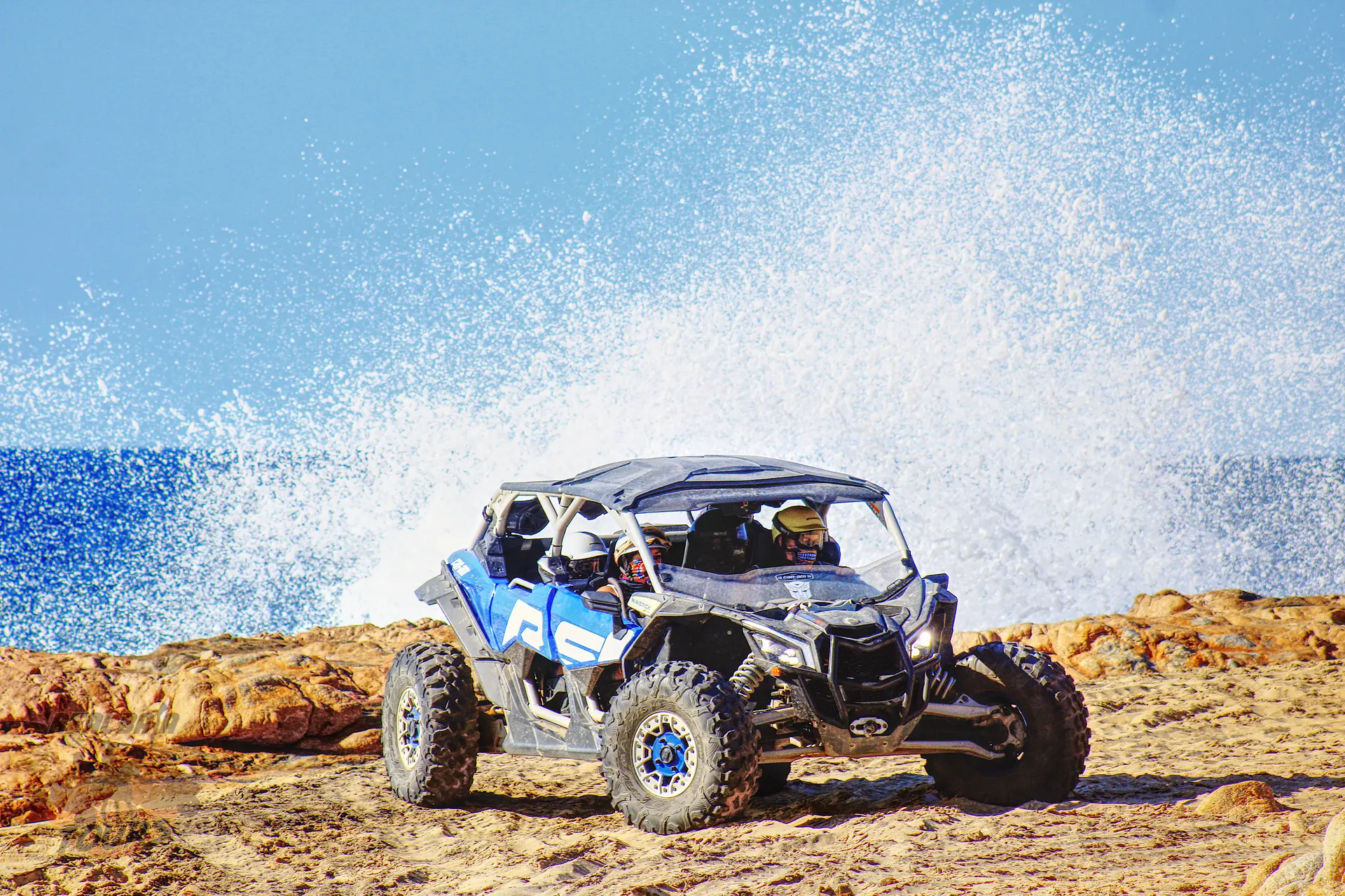 Can Am X3 Blue and black UTV buggy on playa de arena with olas del océano splashing in background, Baja California Sur