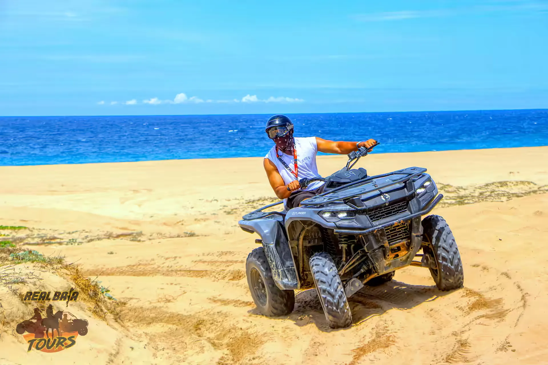 Adventure piloto on ATV on playa de arena with turquoise ocean and blue sky in Baja California Sur