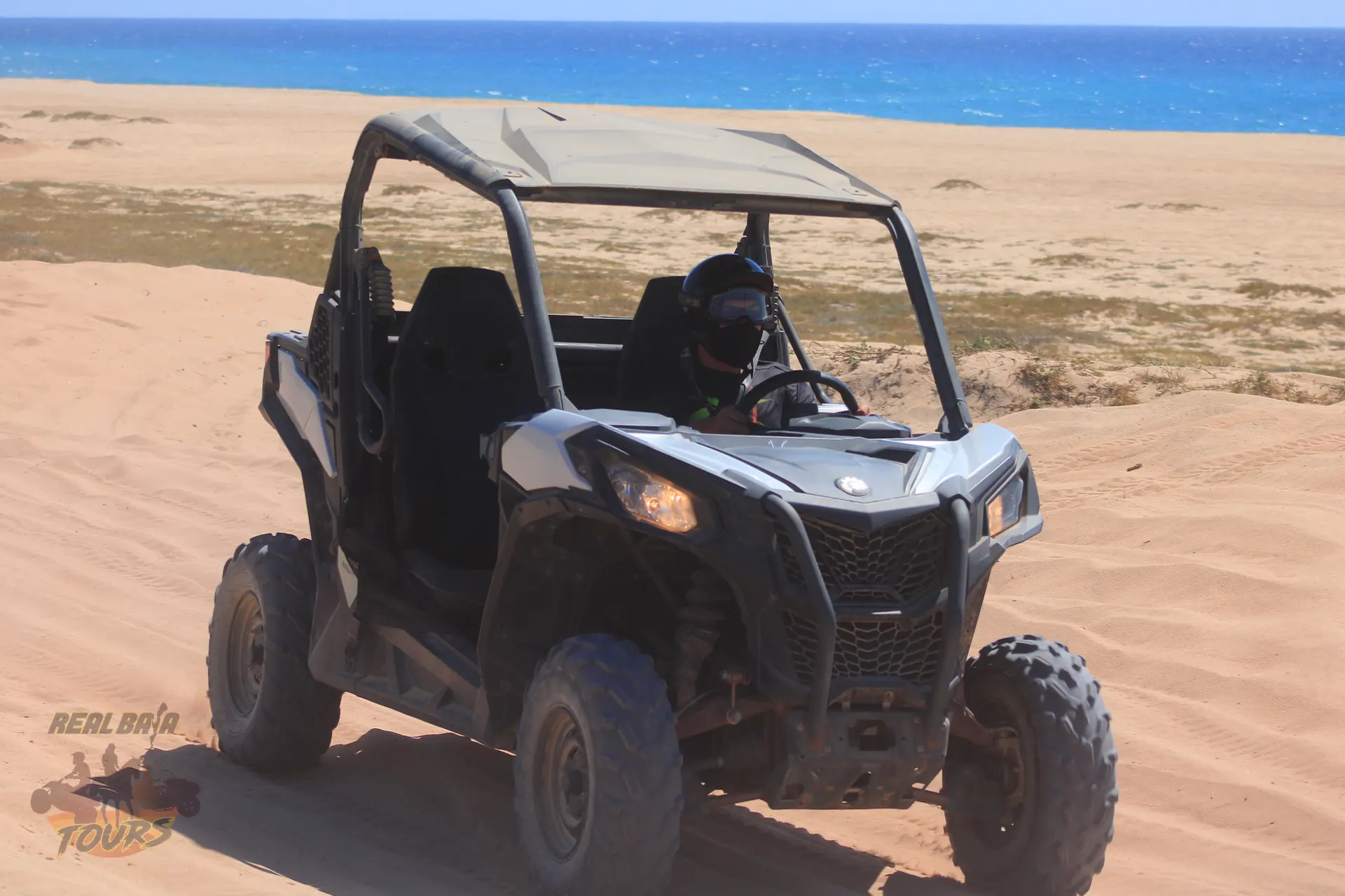 UTV buggy estacionado en playa de arena with crystal blue ocean and desert landscape in Baja California Sur