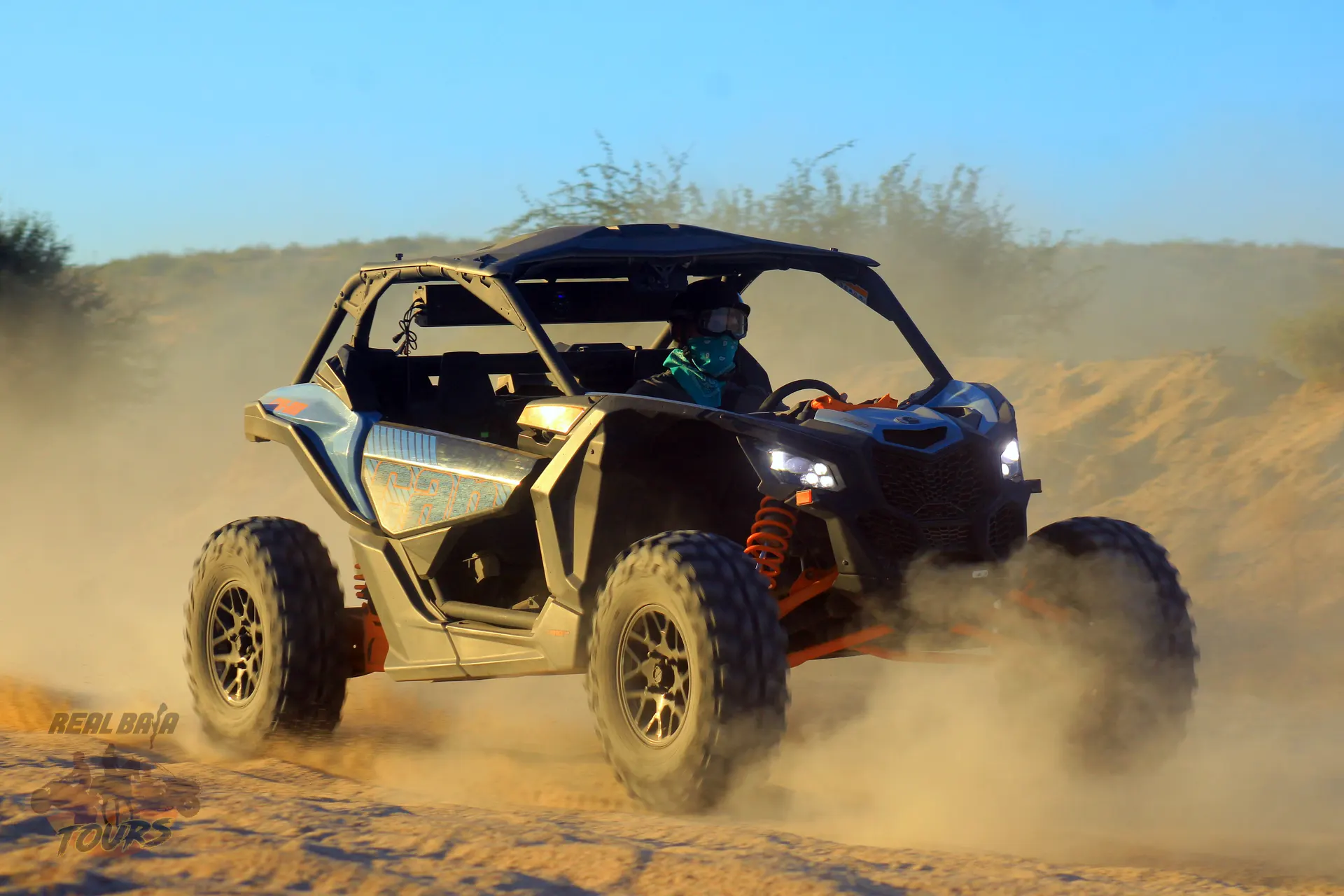 Orange and black UTV levantando polvo while driving through terreno desértico road to candelaria  in Cabo San Lucas