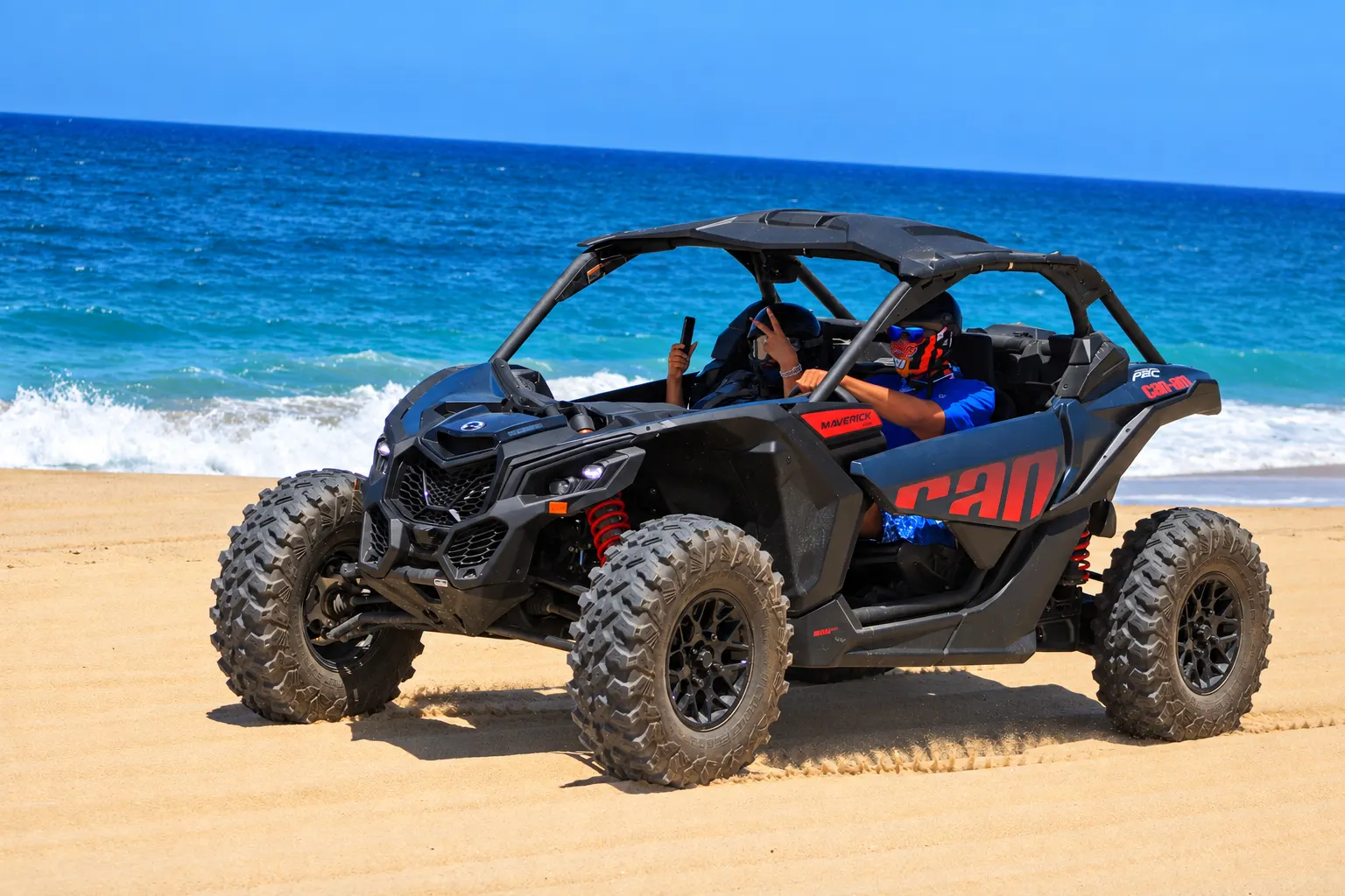 Double X3 Can-Am Maverick with two riders on the beach in Cabo San Lucas