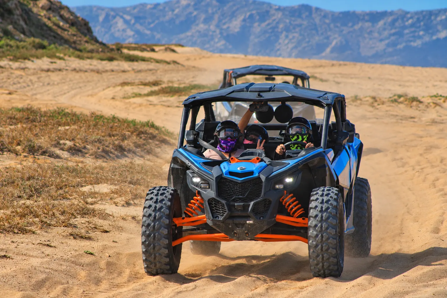 Triple X3 Can-Am Maverick with multiple riders driving on the beach in Cabo San Lucas