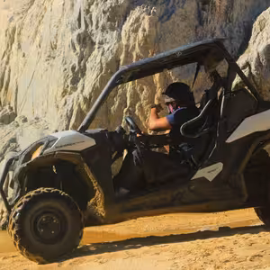 Off-road buggy adventure near waterfall cliff in Baja California Sur desert landscape