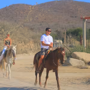 Two riders on horseback along a desert trail near Cabo San Lucas