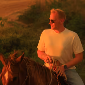 Horseback rider smiling in warm golden sunset light