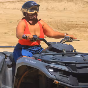 ATV rider wearing a helmet and goggles on her quad bike
