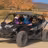 Three adventurers in a Can-Am UTV driving through terreno desértico in Baja California Sur with rocky mountains in background