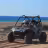 Polaris RZR buggy with two passengers on playa de arena with ocean and blue sky in Baja California Sur