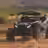 Can-Am X3 splashing through a muddy puddle on a desert trail